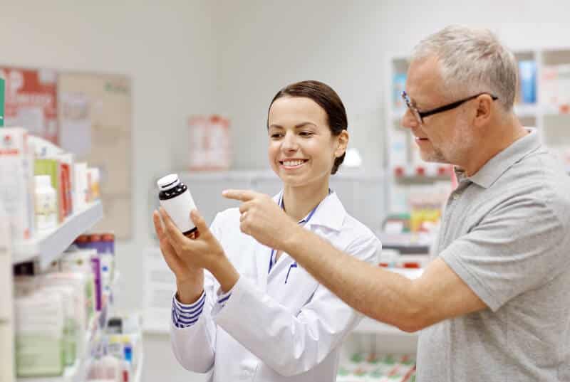 Farmaceutka pokazuje doradza wyjaśnia pacjentowi lek suplement opakowanie, nowy lek,
